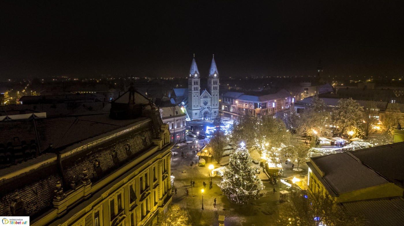 Ünnepi fények és hófedte belváros a magasból